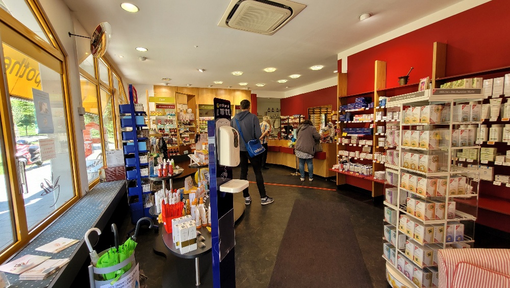 Verkaufsraum der Schwalbanger Apotheke vor dem Umbau — rote Wände und helle Holzfronten