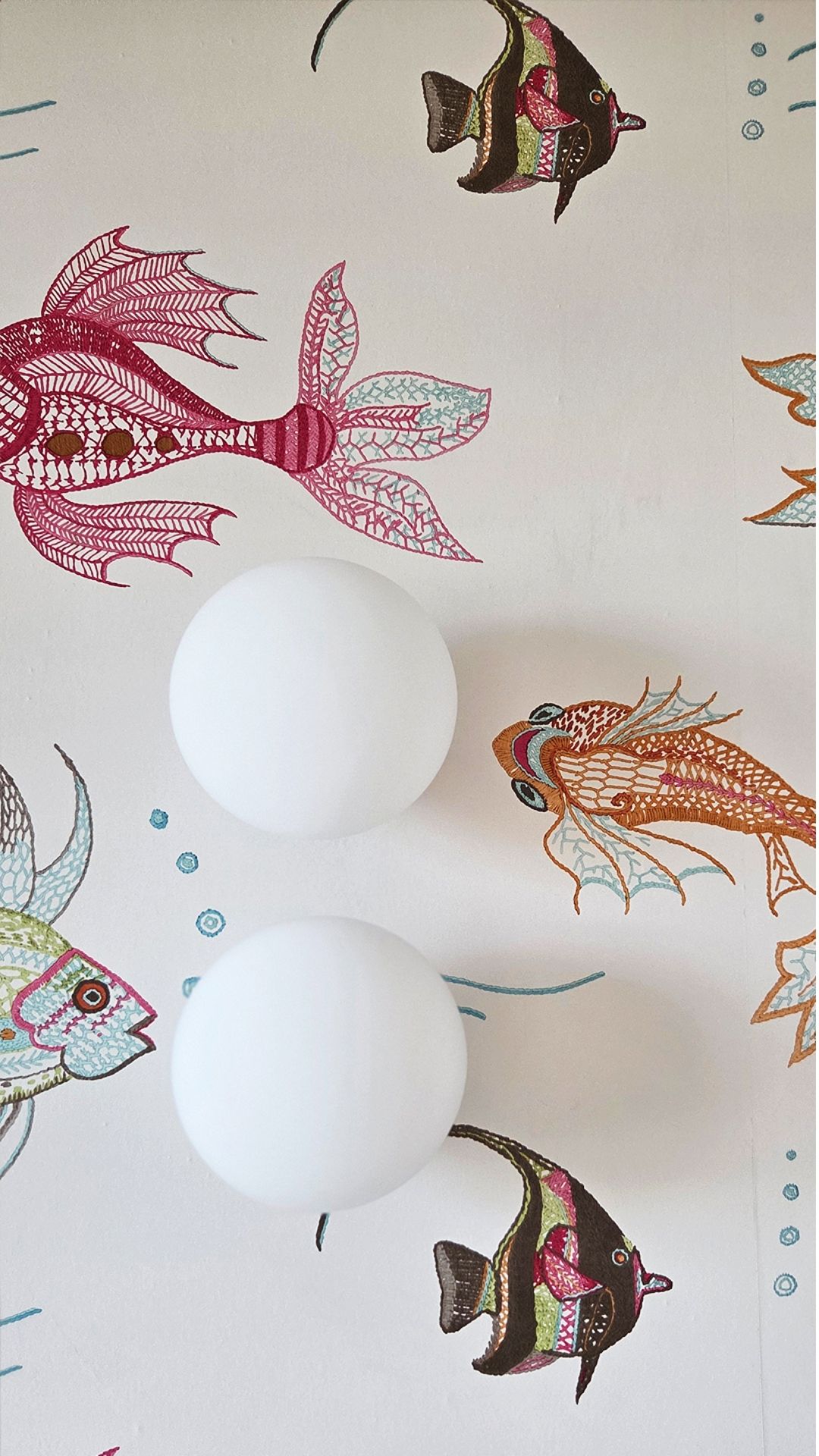 Kinderbad-Detail — bestickte Fisch-Tapete mit Kugelleuchten